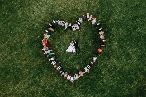 Vestuvių svečiai suformuoja širdį, kūrybiška vestuvių fotografija iš drono, bendra svečių foto